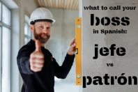 A worker in a construction setting giving a thumbs-up. He wears a hard hat and holds a level on a wall with text overlay about calling a boss in Spanish: 'jefe vs patrón'.