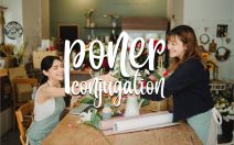 Two women smiling and interacting in a flower shop, surrounded by floral arrangements and supplies. The word "poner conjugation" is displayed in a decorative font over the image.