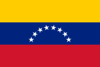 The Venezuelan flag with yellow, blue, and red horizontal stripes and eight white stars arcing across the center blue band.